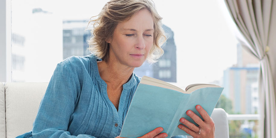 Woman in a blue shirt reading a book